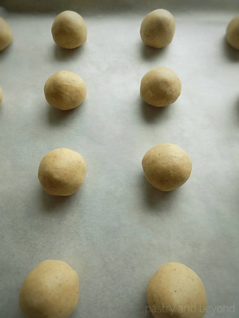 Cookie dough balls on a parchment paper.