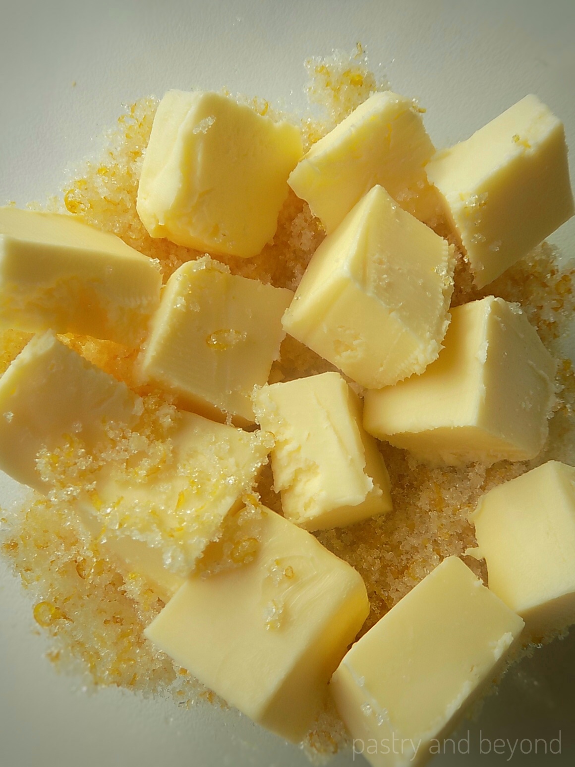 Cubed butter, lemon zest and sugar in a bowl.