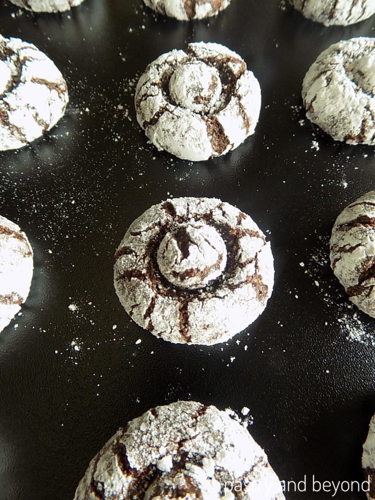 Flourless hazelnut chocolate cookies on a black surface.
