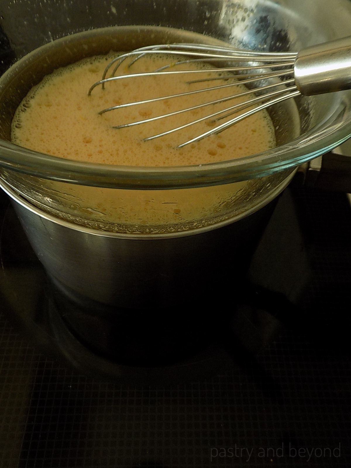 Mixing the mixture that is over bain-marie with a whisk.