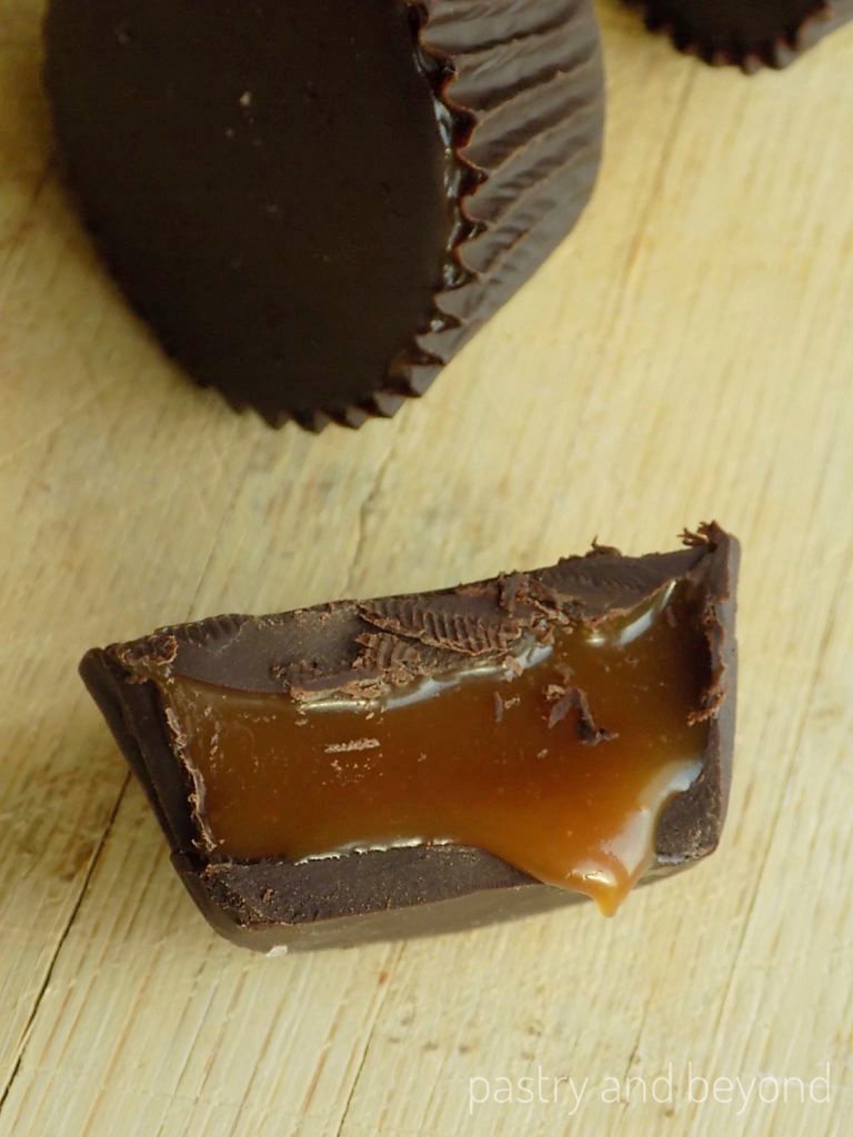 Caramel is dripping from a chocolate cup.