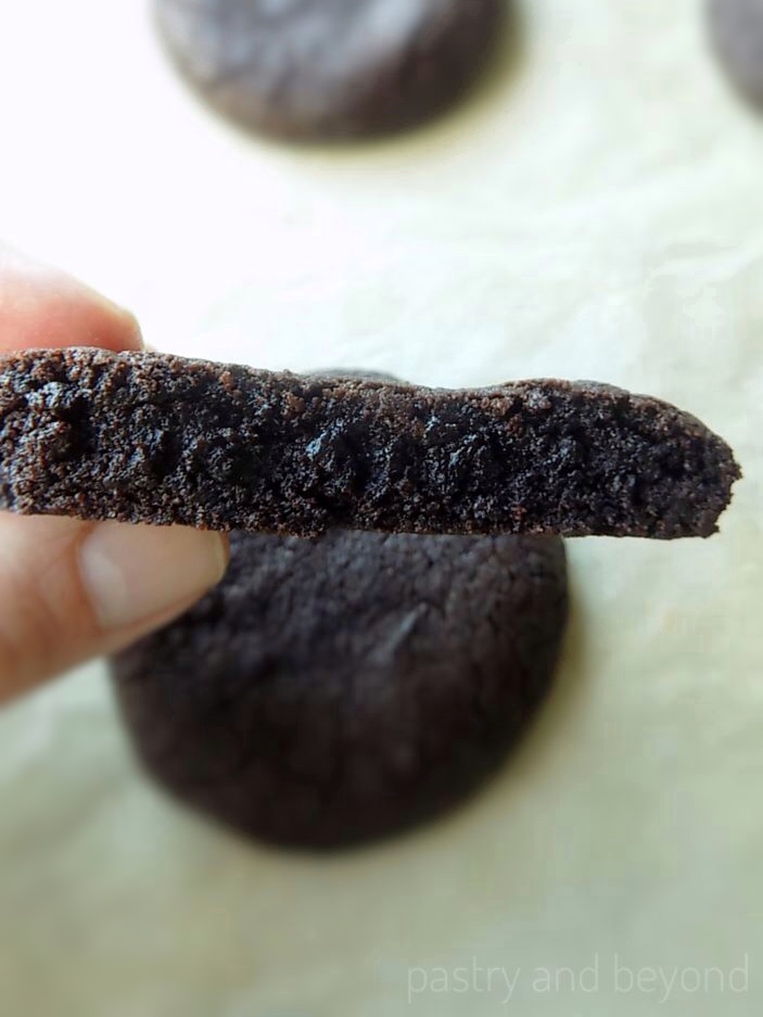 Holding half of a chocolate cookie.