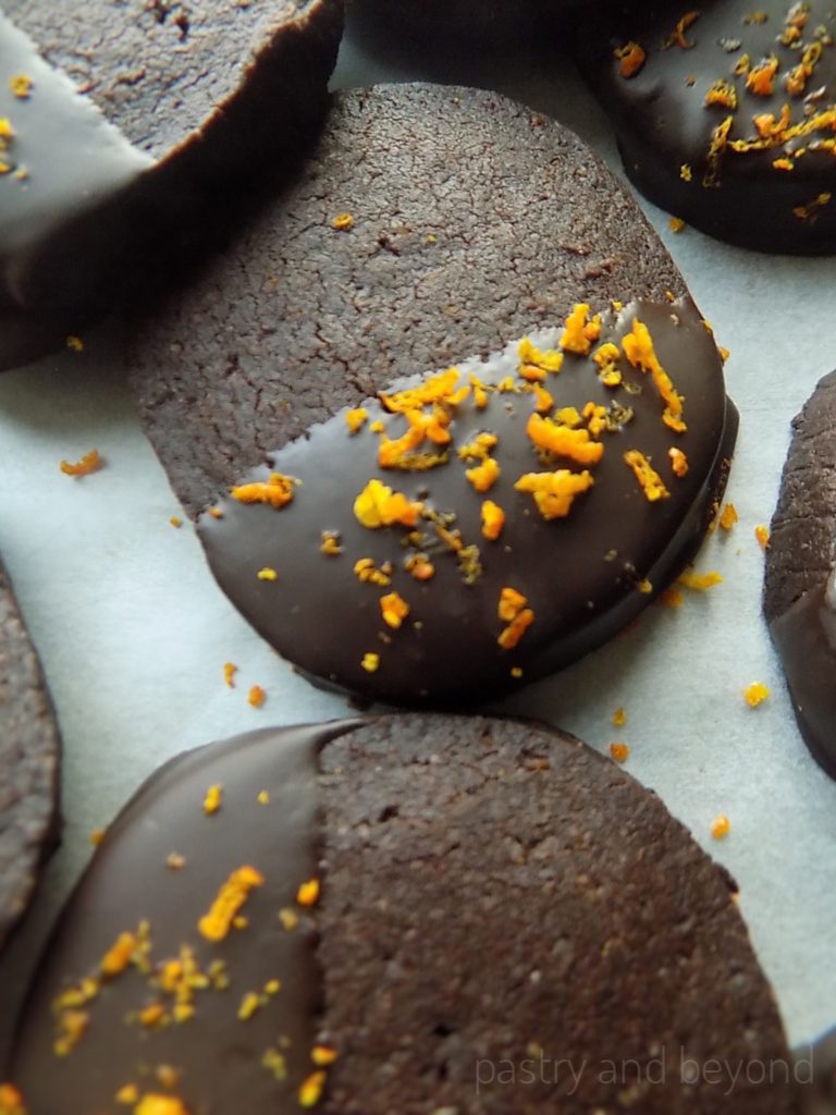 Chocolate and orange shortbread cookies on a white surface.
