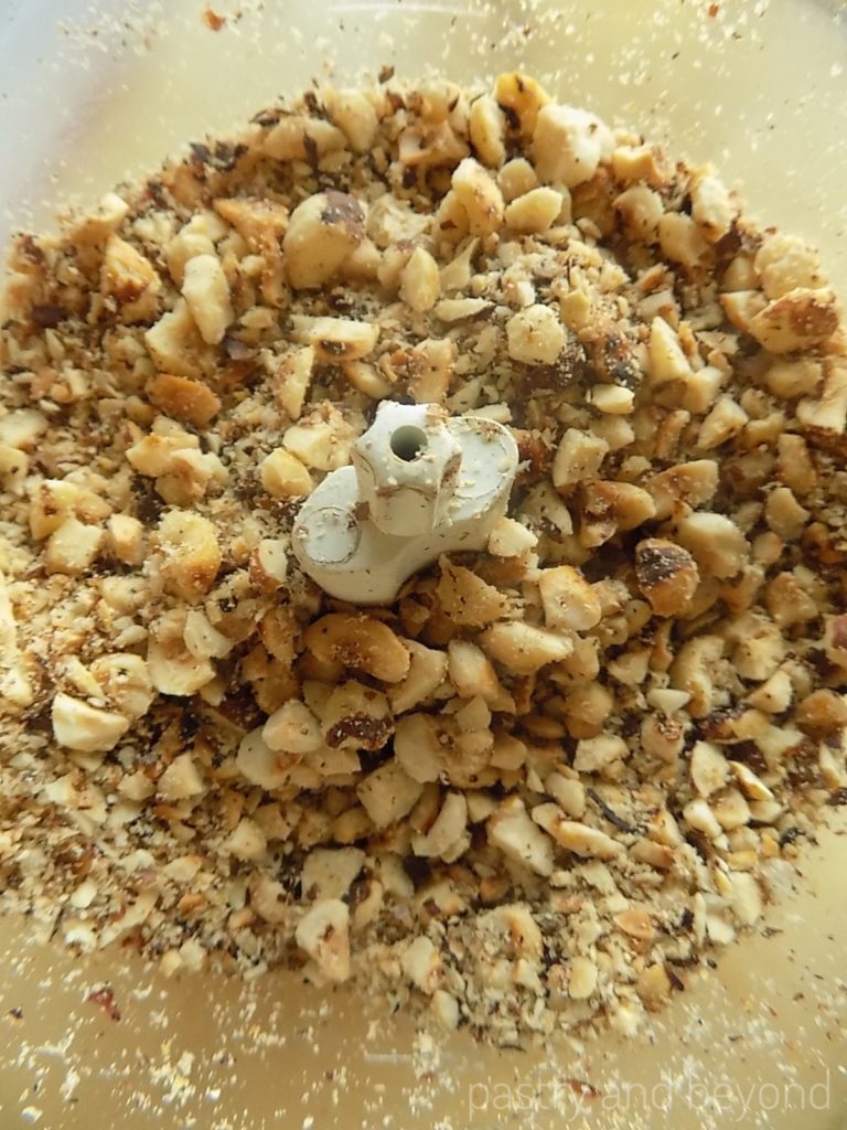 Hazelnuts chopped into big and small pieces in a food processor. 