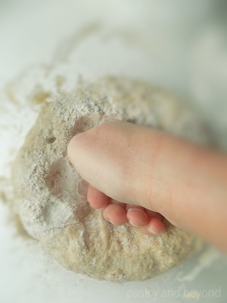 Deflating the dough with knuckle.