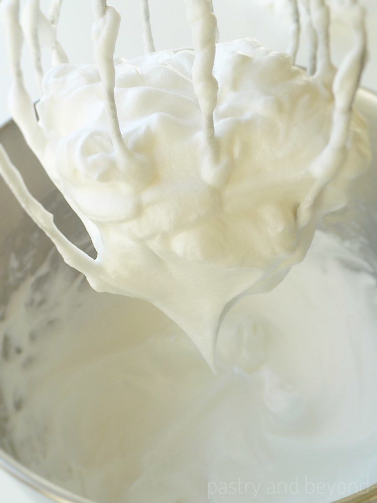 French meringue on a whisk attachment and meringue in a bowl.