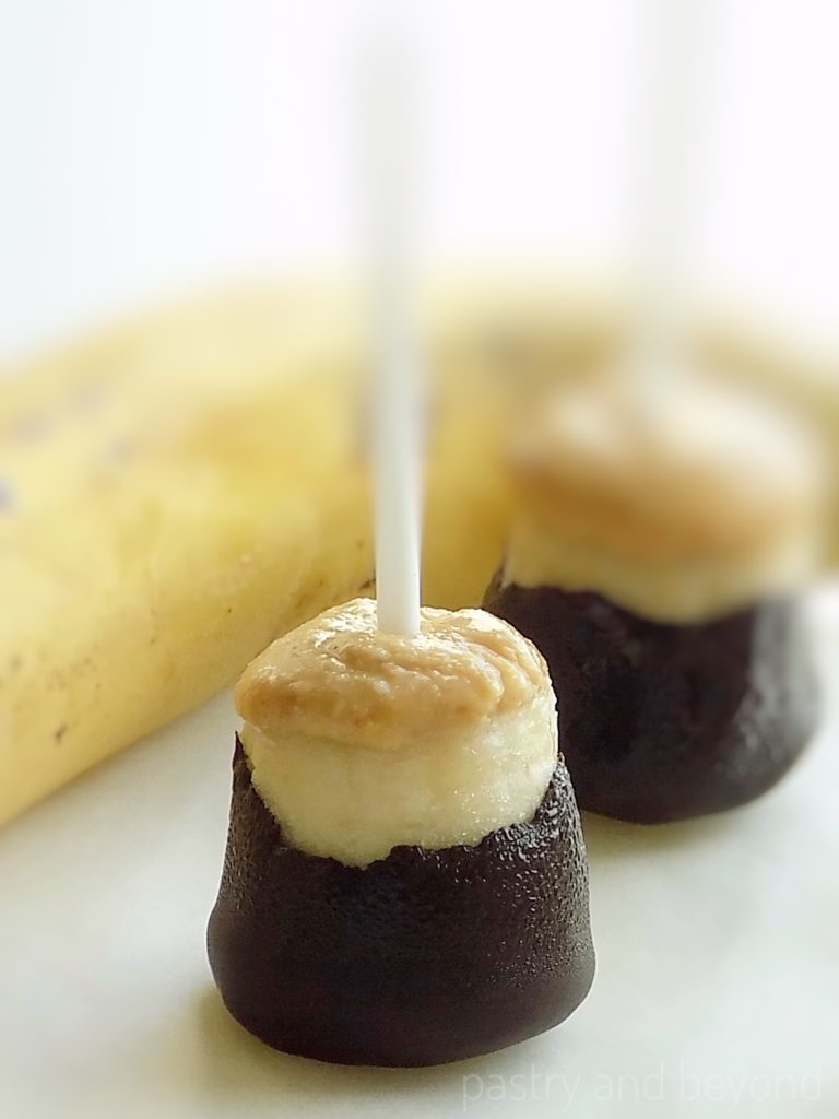 Frozen bananas on a stick with peanut butter and chocolate.