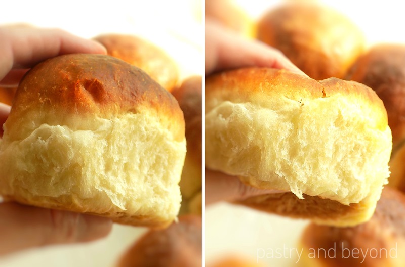 A hand is holding and squeezing the soft dinner roll to show is fluffiness.