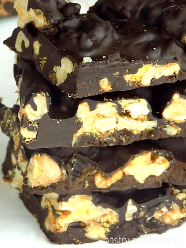 Side view of stacked chocolate covered candied walnuts.