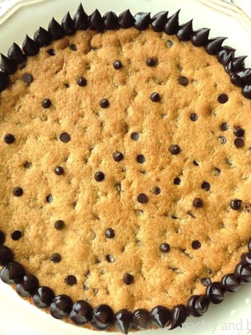 Chocolate chip cookie cake on a cake plate.