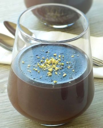 Easy chocolate pudding in a serving glass with pistachios on top.