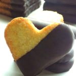 Heart shaped coconut cookies that are dipped into melted semisweet chocolate.