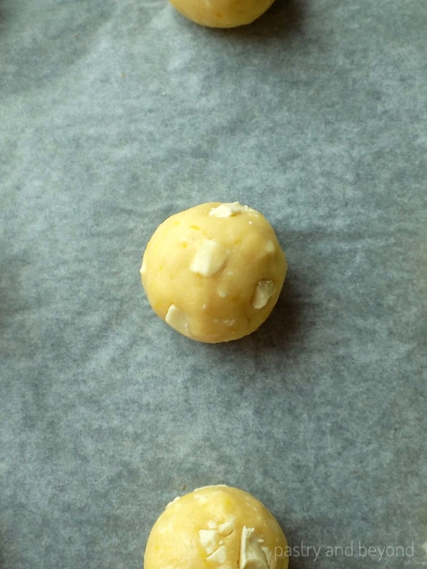 Cookie dough balls on a parchment paper.