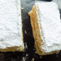 Mille-Feuille slice on a black surface.