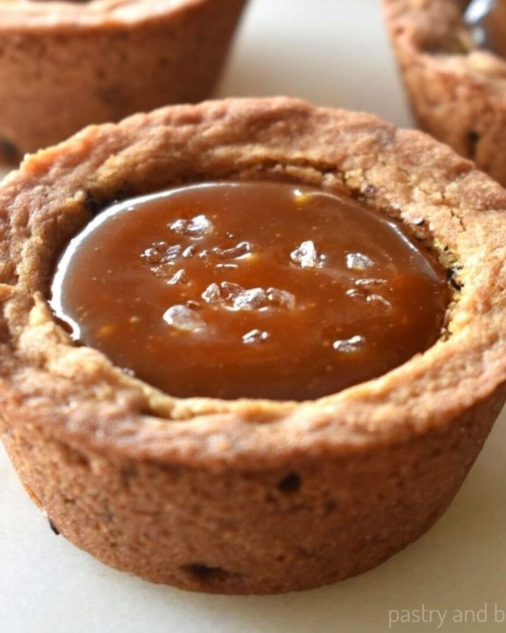 Caramel filled chocolate chip cookie cups with sea salt on top.