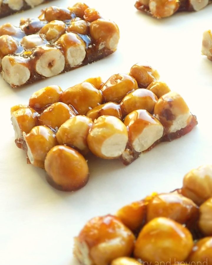 Candied hazelnuts on a white surface.