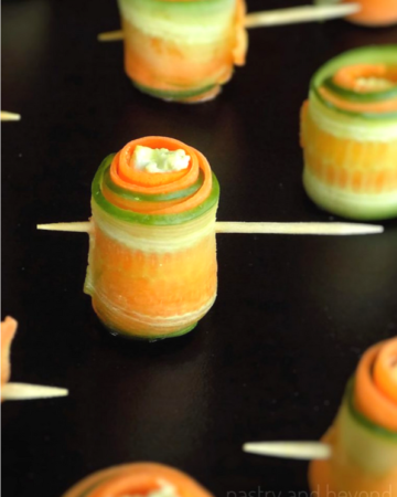 Carrot cucumber rolls on a black surface.