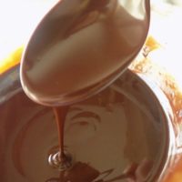 Chocolate ganache dripping from a spoon.