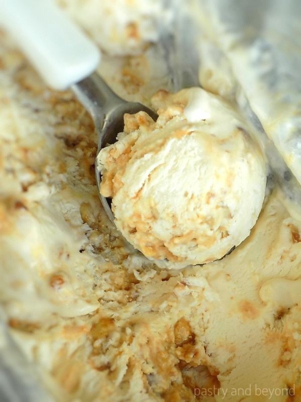 No churn praline ice cream on a white ice cream scoop.