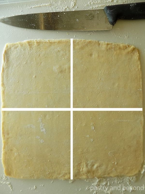 Rolled out square dough cut diagonally and vertically with white lines as an example. 