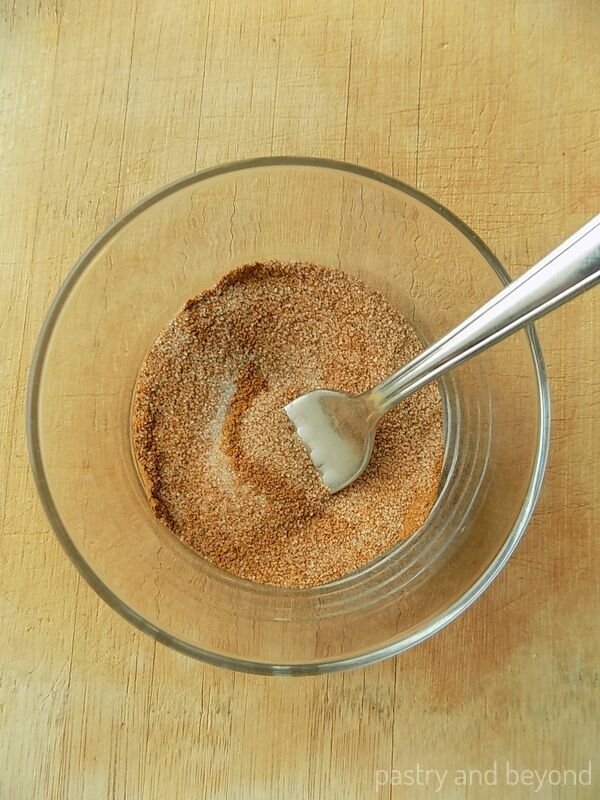 Cinnamon and sugar in a bowl with a fork.