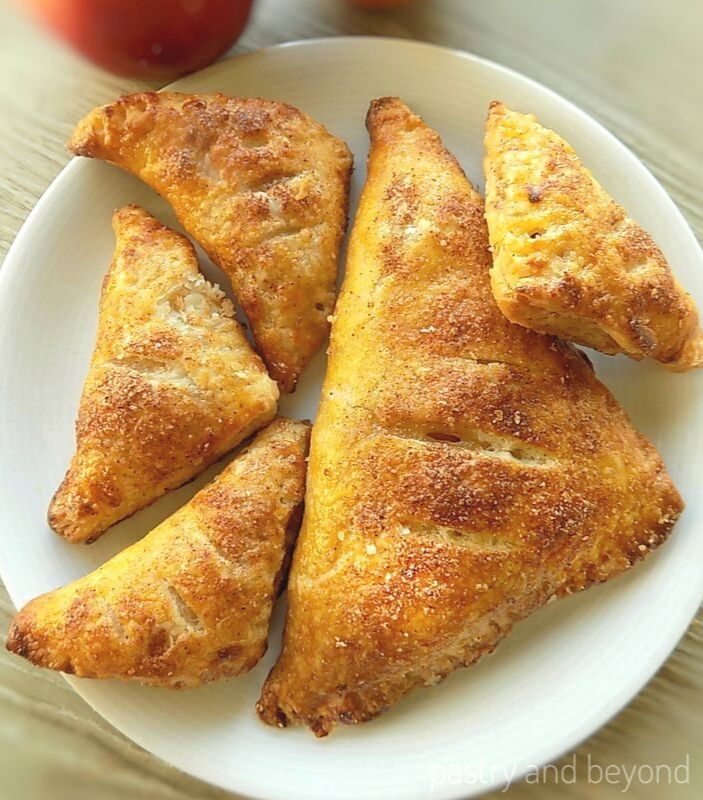 1 Large 4 small puff pastry apple turnovers on a plate.