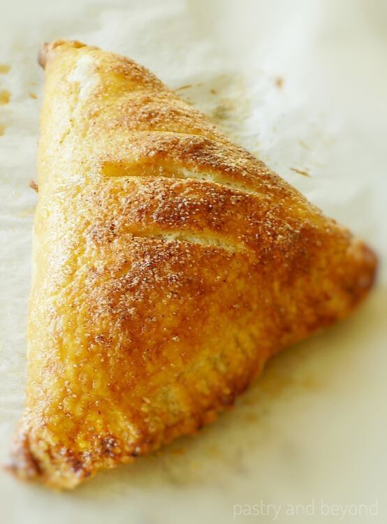Large puff pastry apple turnover on a baking sheet.