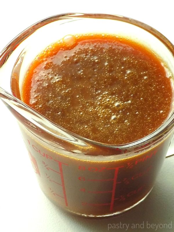 Homemade caramel sauce in a measuring glass.