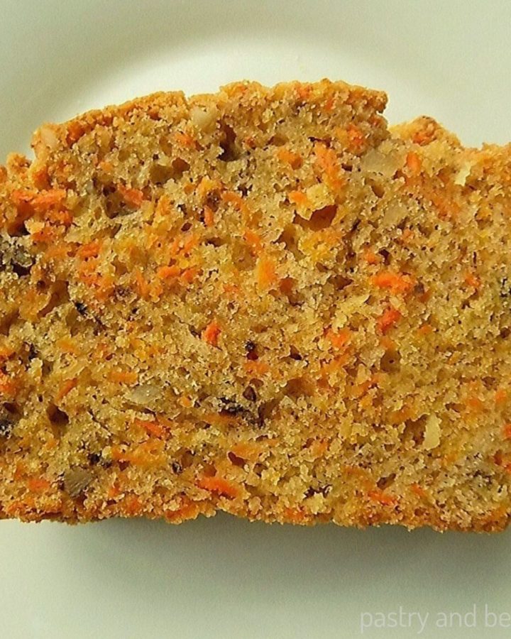 Carrot cake loaf slice on a white plate.
