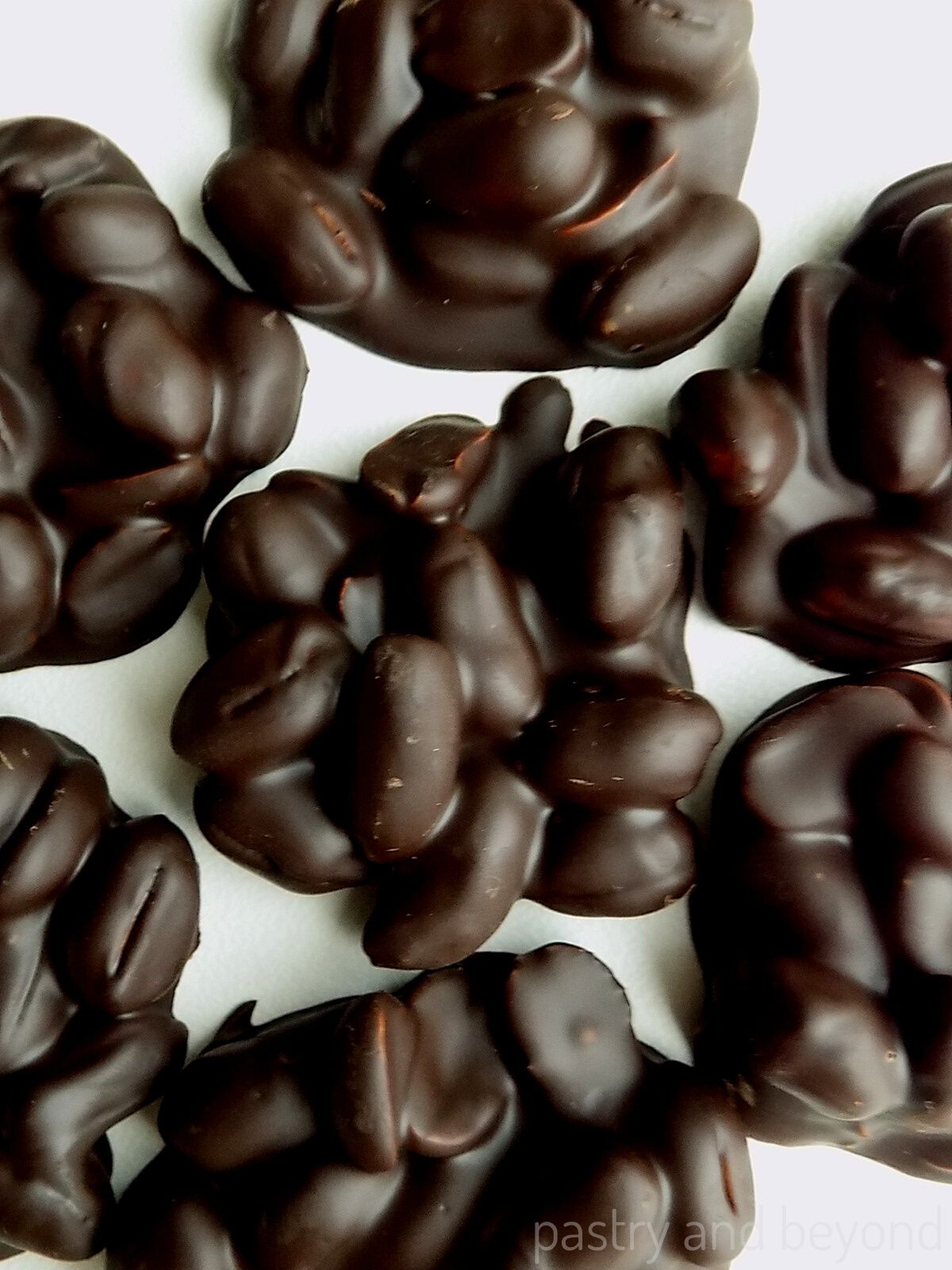 Chocolate peanut clusters on a white surface.