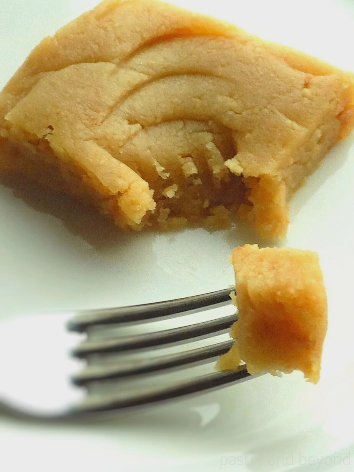 A piece of Turkish halva with a bite on a fork.