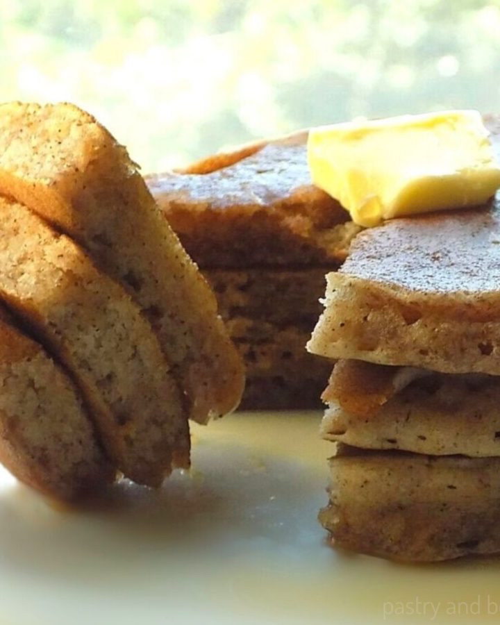 Side view of stacked cinnamon sugar pancakes and slice of stacked pancakes on a fork.