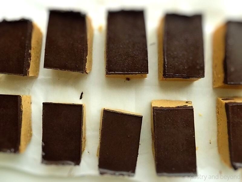 Ten slices of peanut butter bars on a parchment paper.