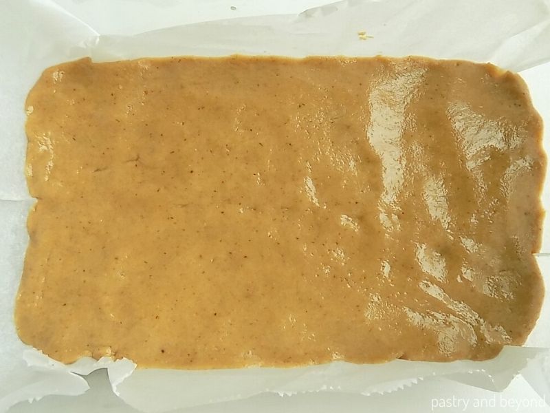 Peanut butter, honey, oat flour mixture spreaded in a rectangle glass dish.