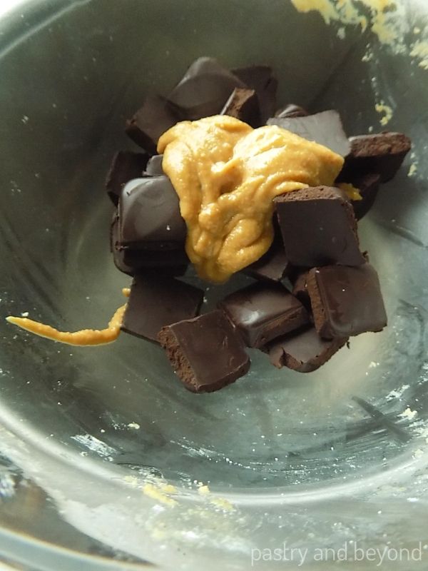 Chocolate pieces and peanut butter in a glass bowl over a saucepan to melt them.