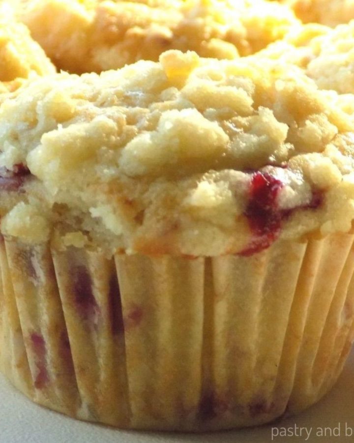 Lemon raspberry streusel muffins on a white surface.