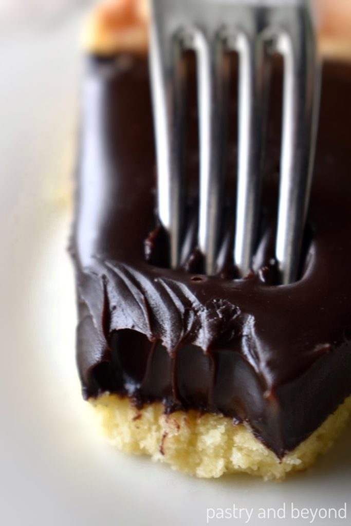 Taking a piece of chocolate ganache tart with a fork.