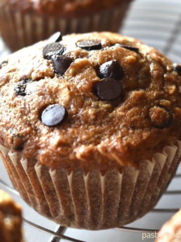 Banana oatmeal chocolate chip muffins on a wire rack.