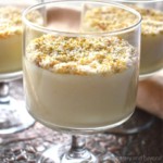 Almond pudding in serving glasses with ground pistachios and shedded coconut on top.