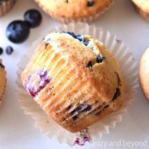 Side view of blueberry chocolate chip muffin on a cupcake liner.