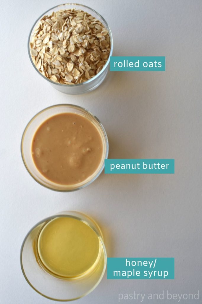 Ingredients for oatmeal balls in small cups on a white surface.