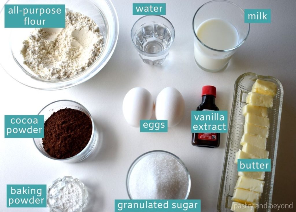 Ingredients for chocolate loaf cake on a white surface.