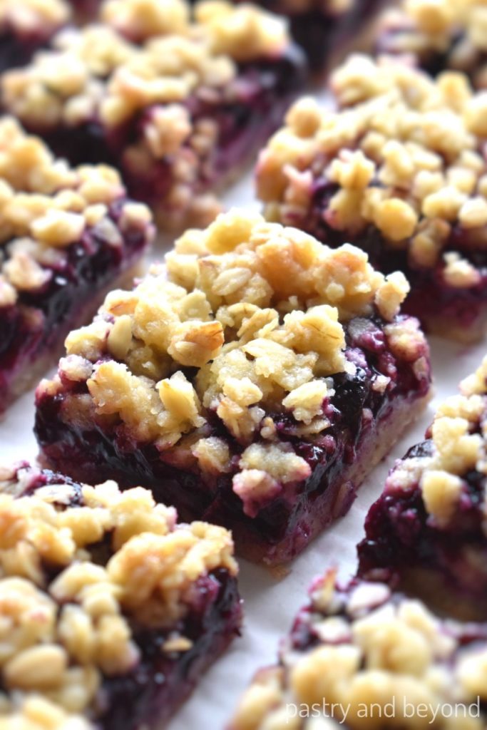 Blueberry oatmeal bars in a row on a parchment paper.