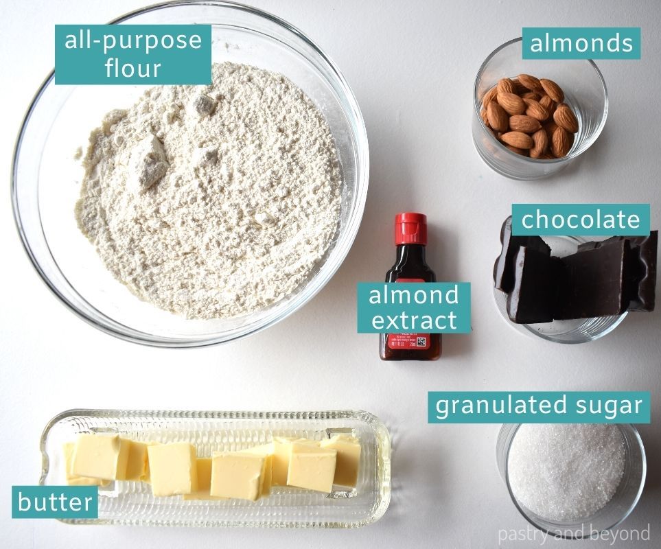 Ingredients of almond extract cookies on a white surface.
