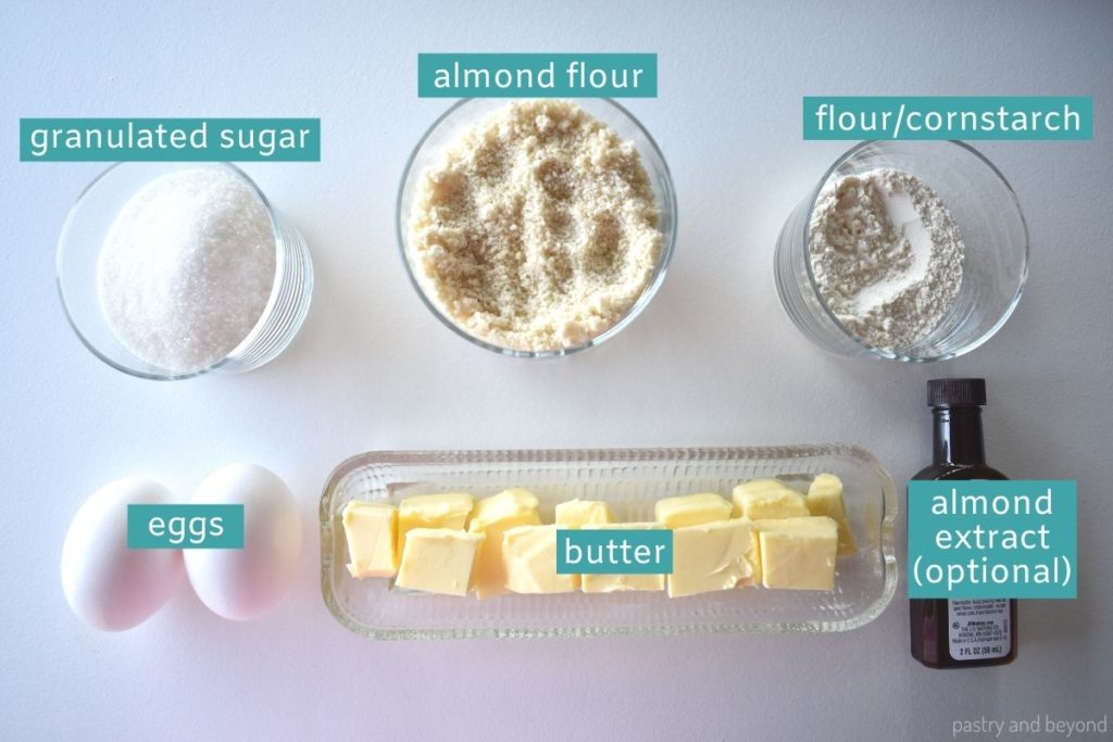 Ingredients of almond cream on a white surface.