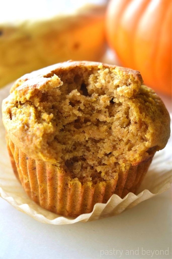 Pumpkin banana muffin with a bite taken from it.