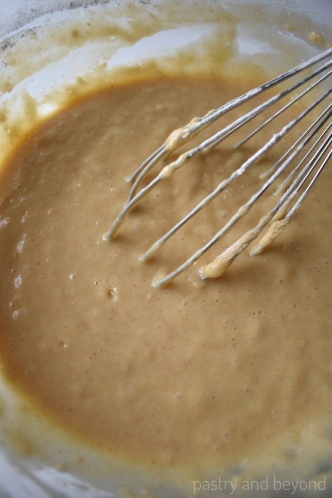 Cinnamon muffin batter after wet and dry ingredients mixed with a whisk in a bowl.