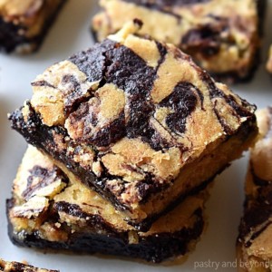 Stacked brownie blondies on a white surface.