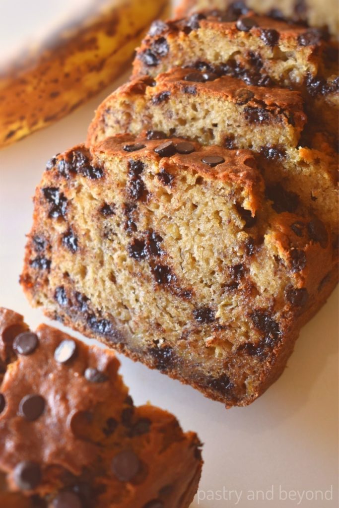 Slices of banana chocolate chip bread on a white surface.