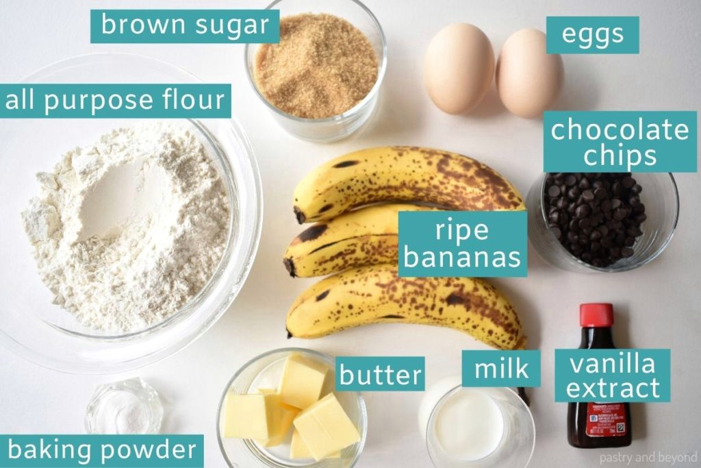 Ingredients for banana chocolate chip bread on a white surface.